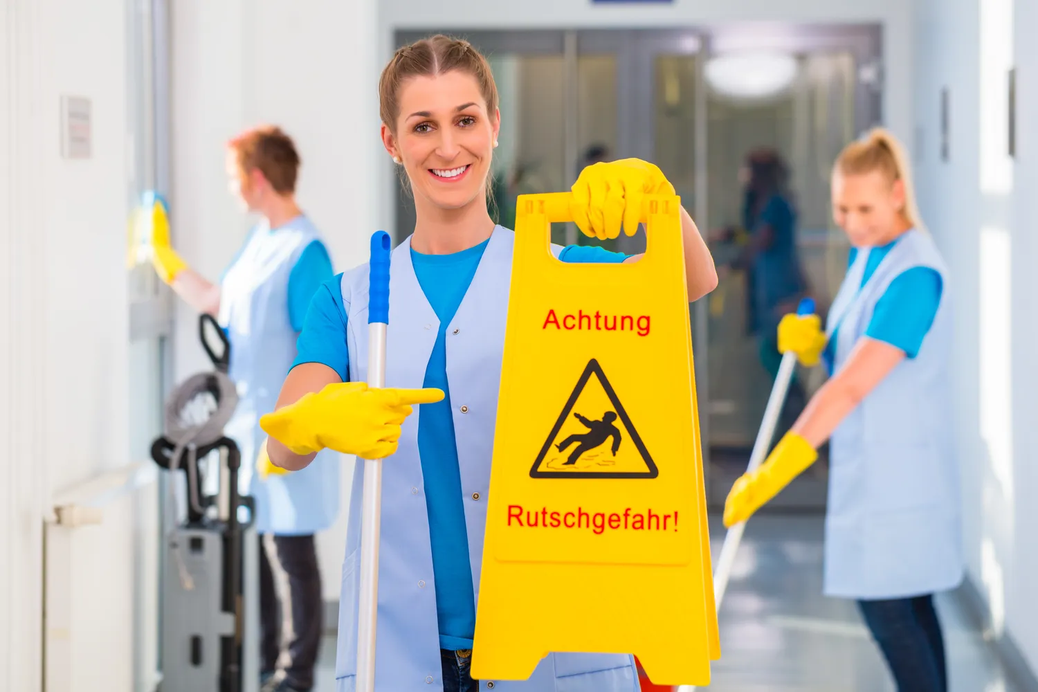 Ahmad Almorad – Reinigungsservice – Putzfrau zeigt Warnschild